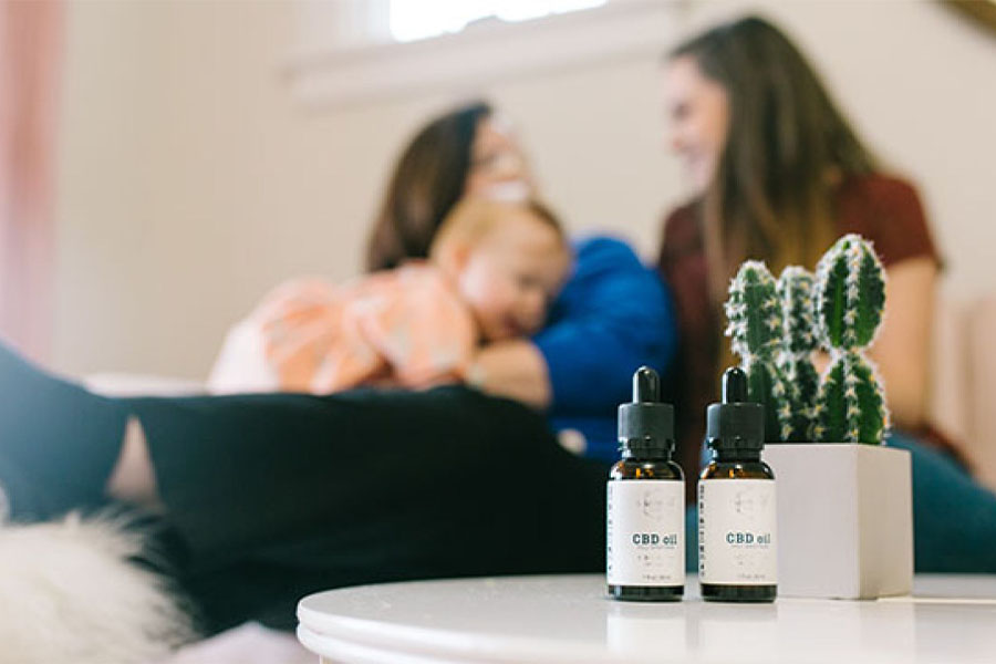 CBD oil in the foreground with a family in the background.